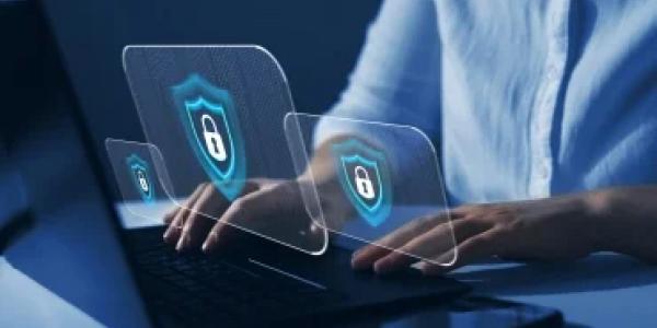 person typing on keyboard with three locked laptop images