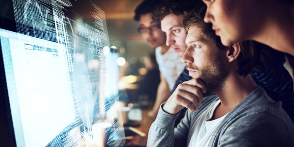 multiple people staring intently at a monitor display