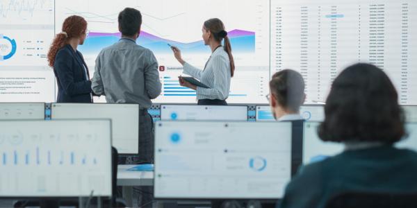  Image of a professional team analyzing data on a large screen in a modern office environment.