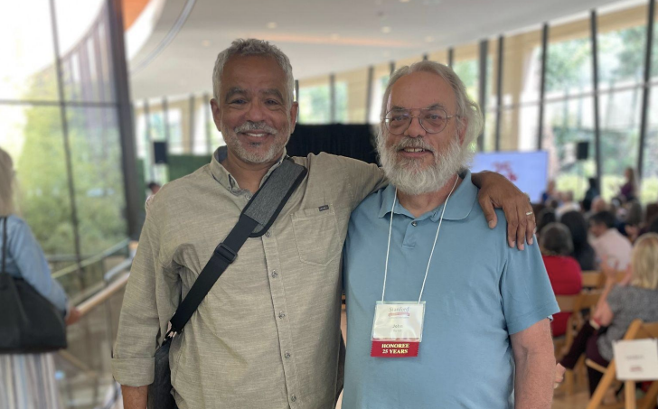 Neal Adams and John Bartelt smiling while standing in the lobby of the Bing Concert Hall