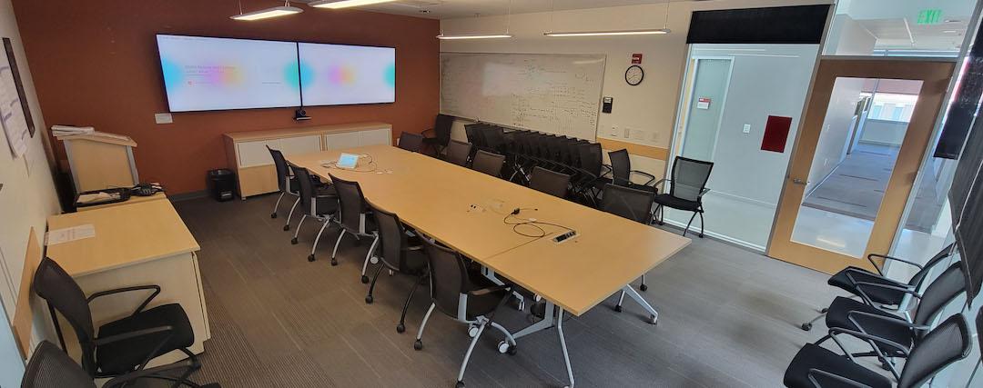 table , chairs and two display screens 