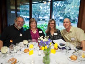 john, wife, colleagues sitting at dinner table